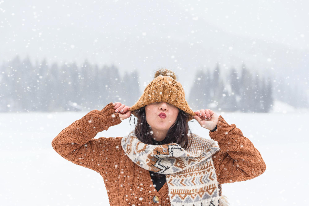 Portrait of a young woman in winter snowfall outdoors happy